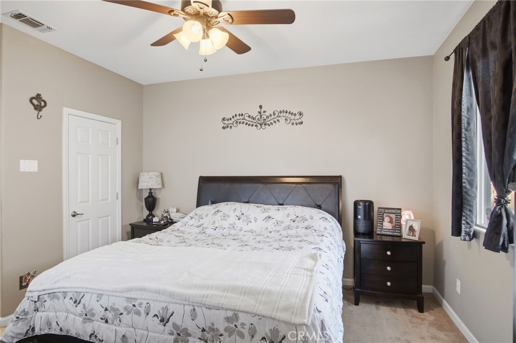 450 Beckman Way Merced, CA 95348 - Photo 18 of 22 a bedroom with a bed and a chandelier