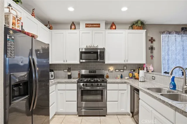 a kitchen with stainless steel appliances granite countertop a refrigerator stove and sink
