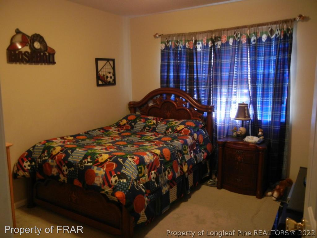 5630 Weatherford Road Fayetteville, NC 28303 - Photo 13 of 16 a bedroom with a bed and wooden floor