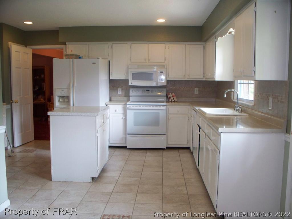 5630 Weatherford Road Fayetteville, NC 28303 - Photo 5 of 16 a kitchen with a cabinets and a stove top oven