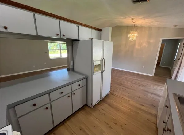 a kitchen with cabinets and wooden floor