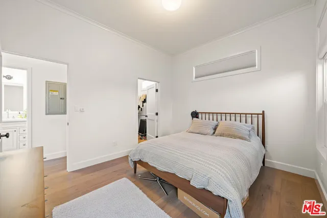 a bedroom with a large bed and a wooden floor