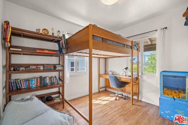 a view of an empty room with furniture wooden floor and a book shelf