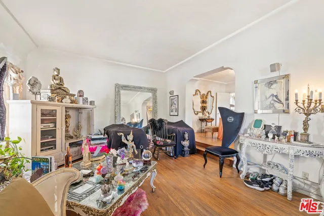 a dining room with wooden floor a chandelier a wooden table and chairs