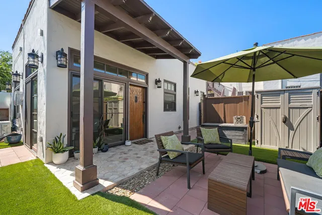 a view of a backyard with table and chairs under an umbrella