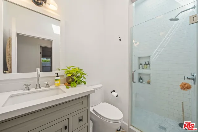 a bathroom with a sink mirror vanity and toilet