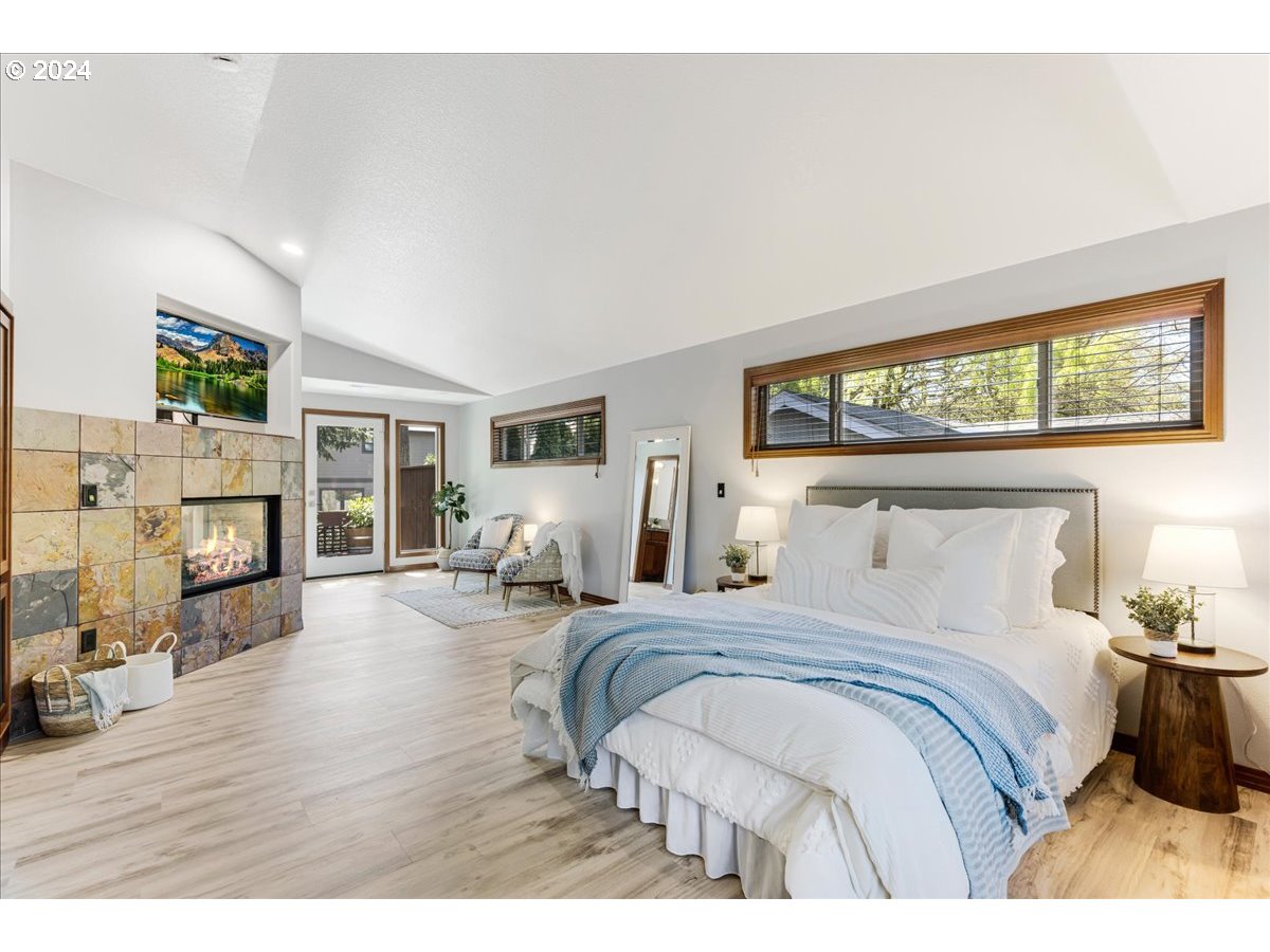 4820 Southwest Marigold Street Portland, OR 97219 - Photo 11 of 34 a bedroom with a bed and wooden floor