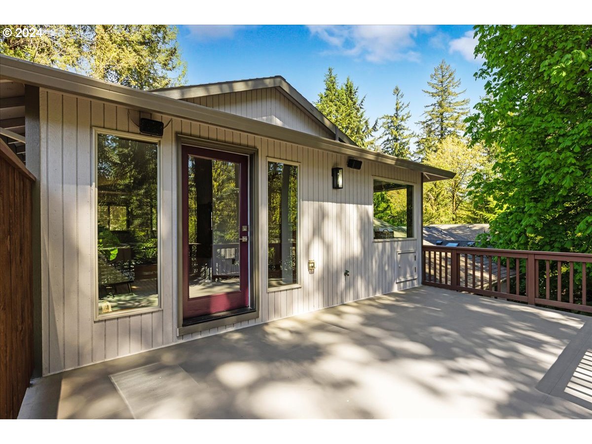 4820 Southwest Marigold Street Portland, OR 97219 - Photo 17 of 34 a view of a house with large windows and a small yard