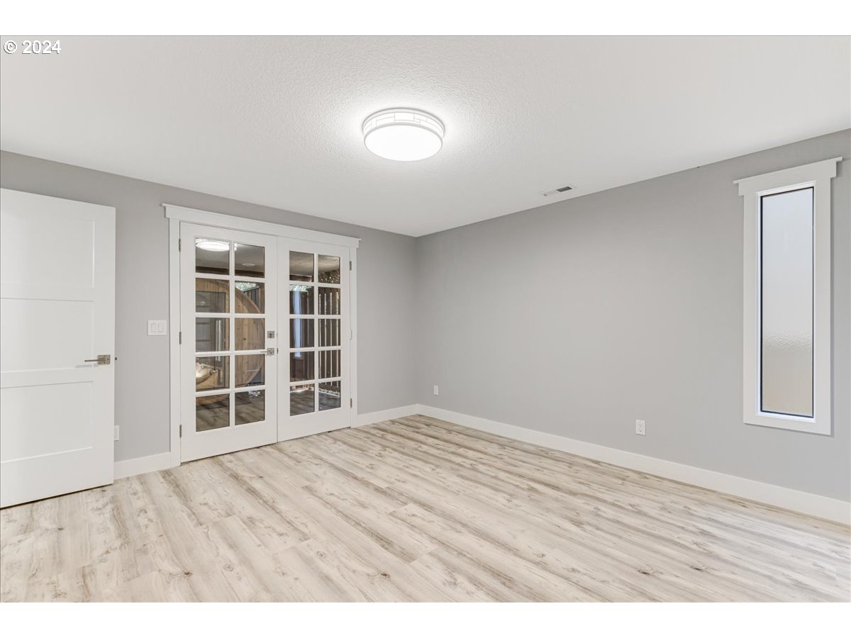 4820 Southwest Marigold Street Portland, OR 97219 - Photo 20 of 34 a view of an empty room with wooden floor and windows