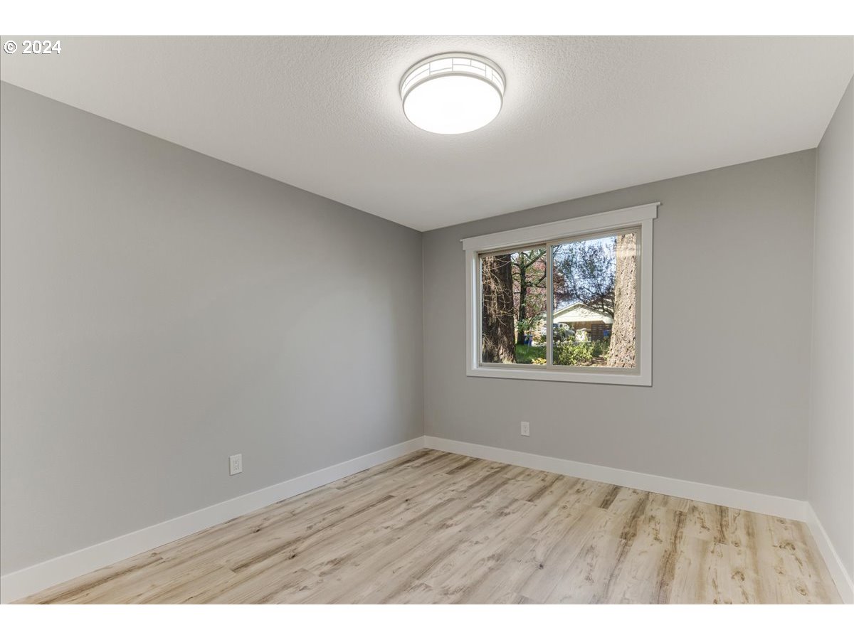 4820 Southwest Marigold Street Portland, OR 97219 - Photo 24 of 34 a view of an empty room with wooden floor and window