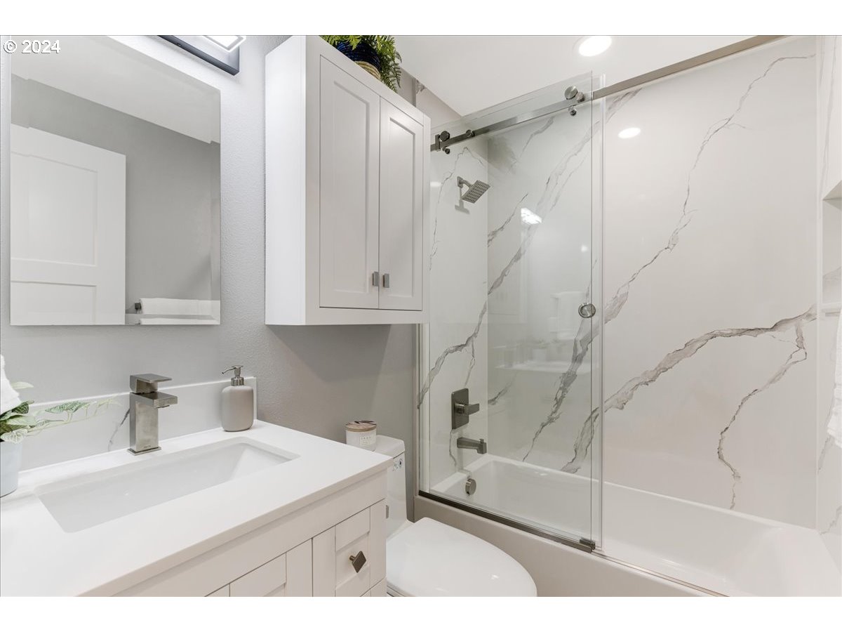 4820 Southwest Marigold Street Portland, OR 97219 - Photo 25 of 34 a bathroom with a sink a mirror and a shower
