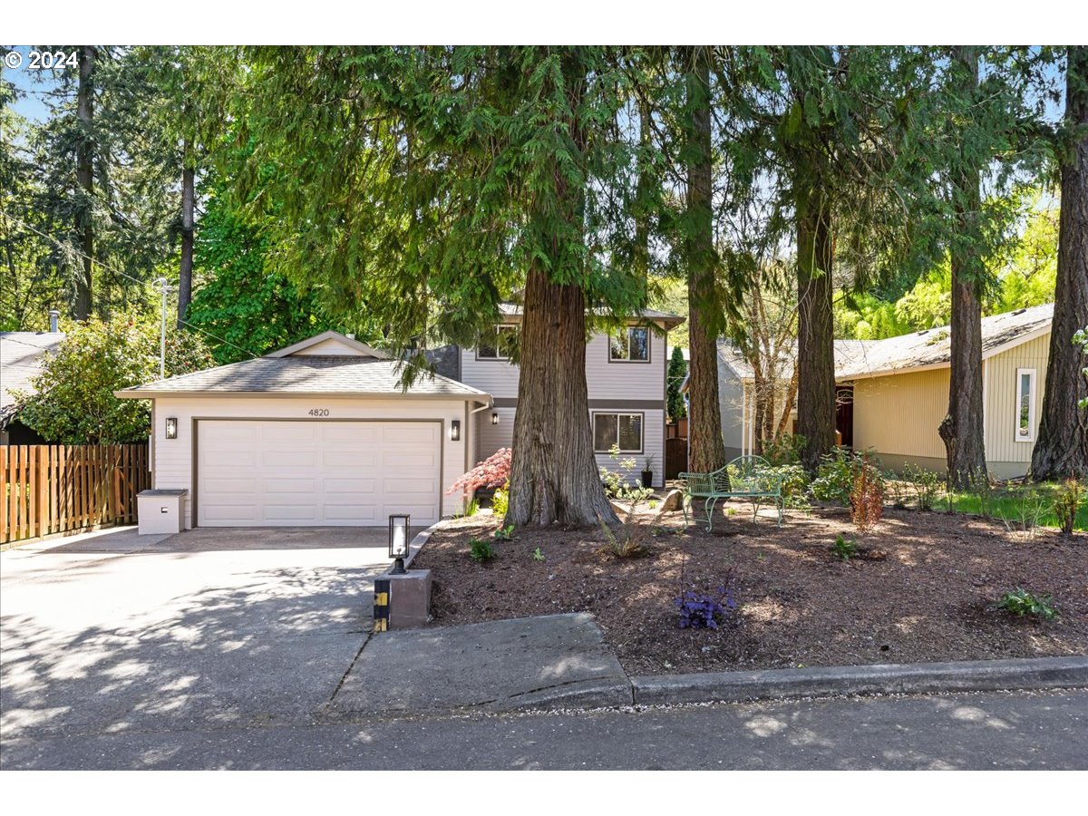 4820 Southwest Marigold Street Portland, OR 97219 - Photo 32 of 34 a view of yard and house with trees in the background