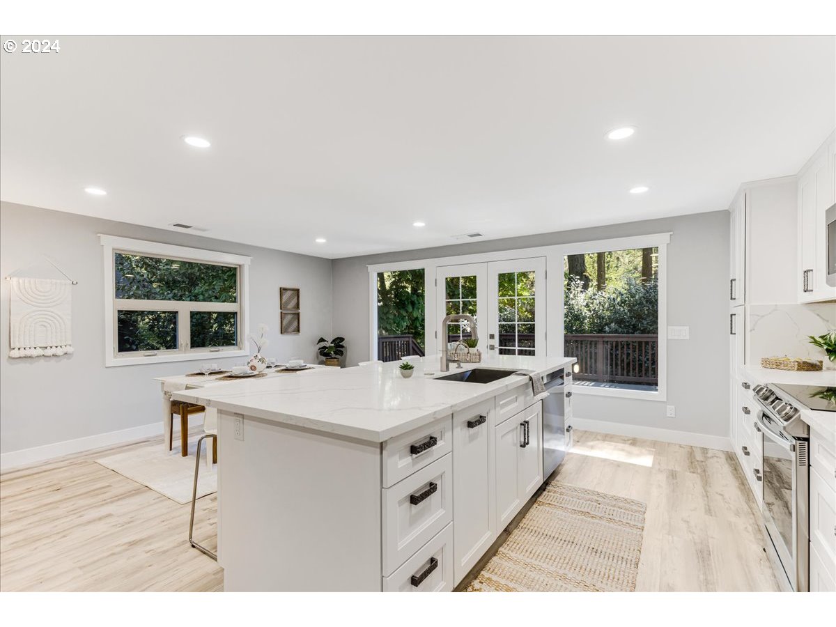 4820 Southwest Marigold Street Portland, OR 97219 - Photo 5 of 34 a large white kitchen with sink stove and cabinets