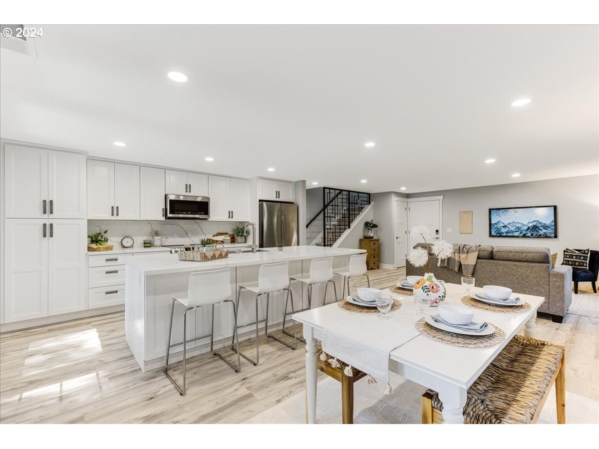 4820 Southwest Marigold Street Portland, OR 97219 - Photo 7 of 34 a open kitchen with stainless steel appliances kitchen island granite countertop a dining table chairs and view kitchen