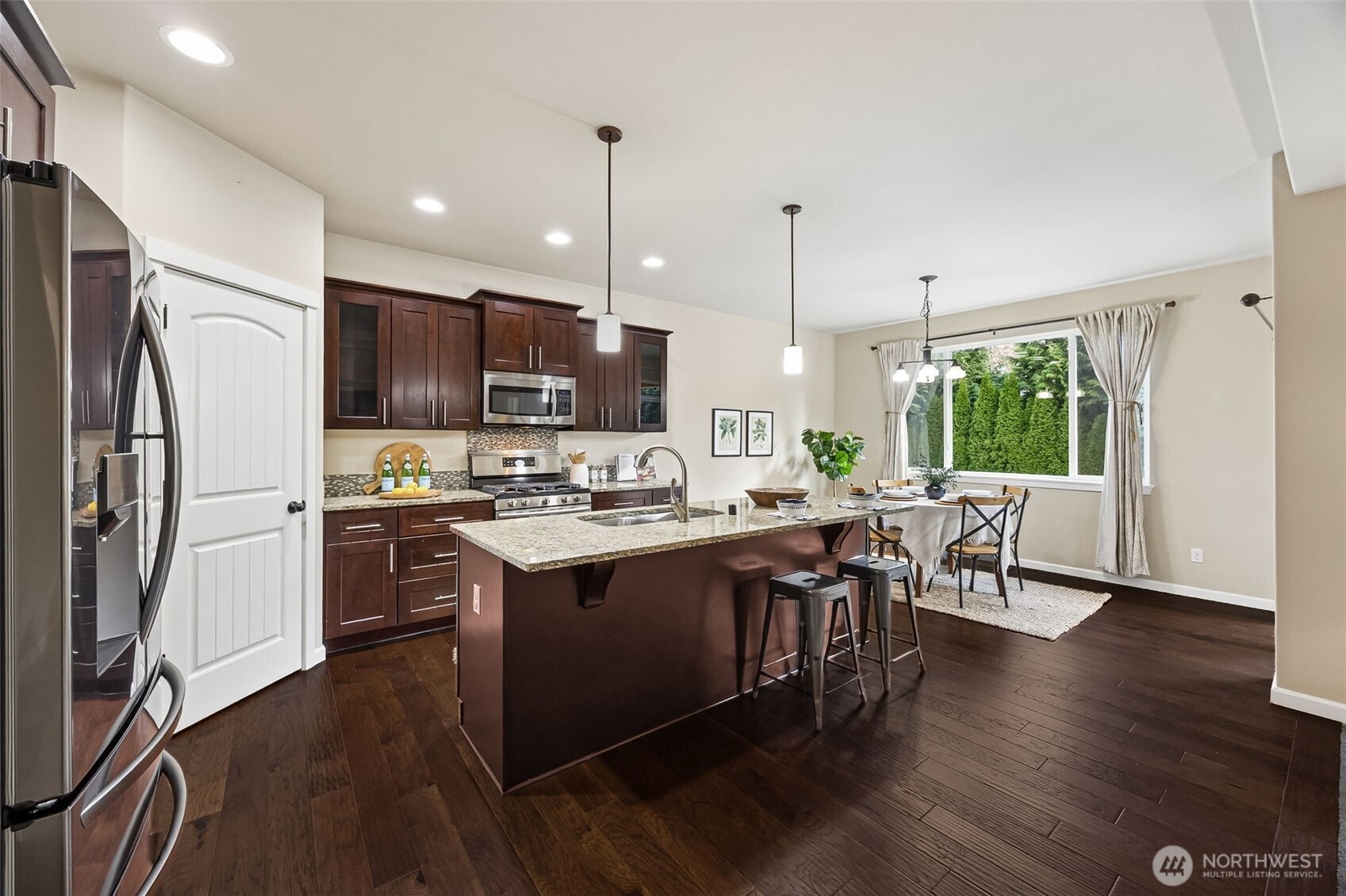 4703 Prestwick Lane Southeast Lacey, WA 98513 - Photo 8 of 40 a kitchen with stainless steel appliances granite countertop a table chairs microwave and refrigerator