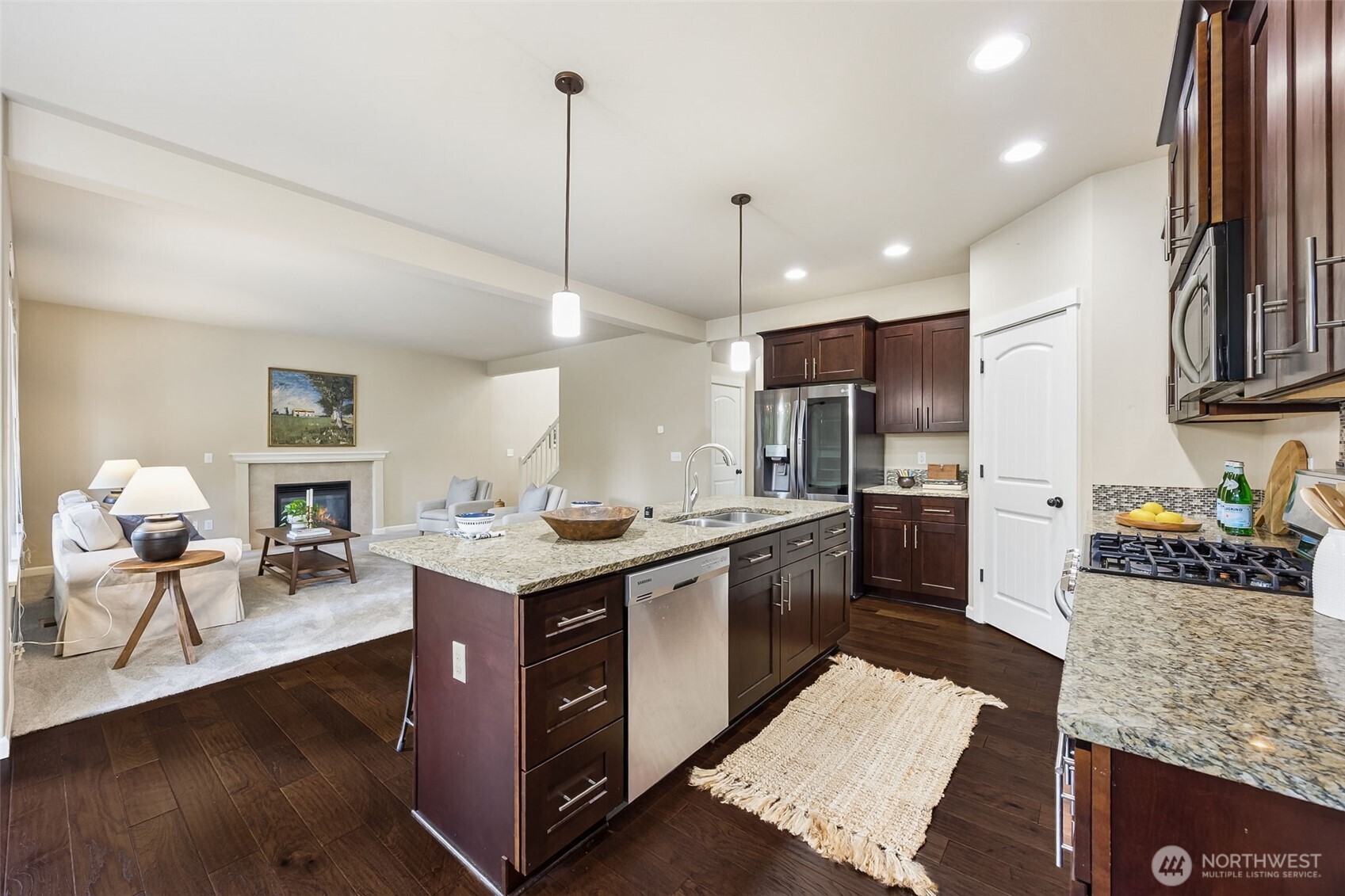 4703 Prestwick Lane Southeast Lacey, WA 98513 - Photo 9 of 40 a kitchen with stainless steel appliances granite countertop a stove top oven a sink dishwasher and a refrigerator with wooden floor