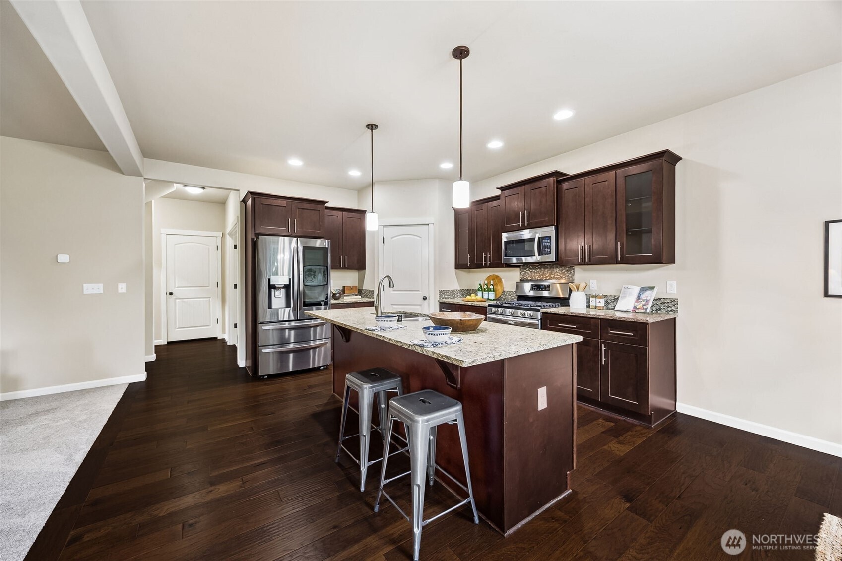 4703 Prestwick Lane Southeast Lacey, WA 98513 - Photo 10 of 40 a kitchen with stainless steel appliances kitchen island granite countertop a stove a sink a refrigerator and a microwave