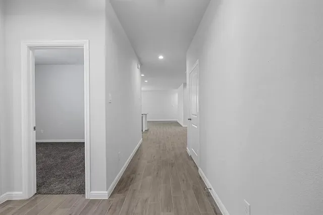 a view of a hallway with wooden floor