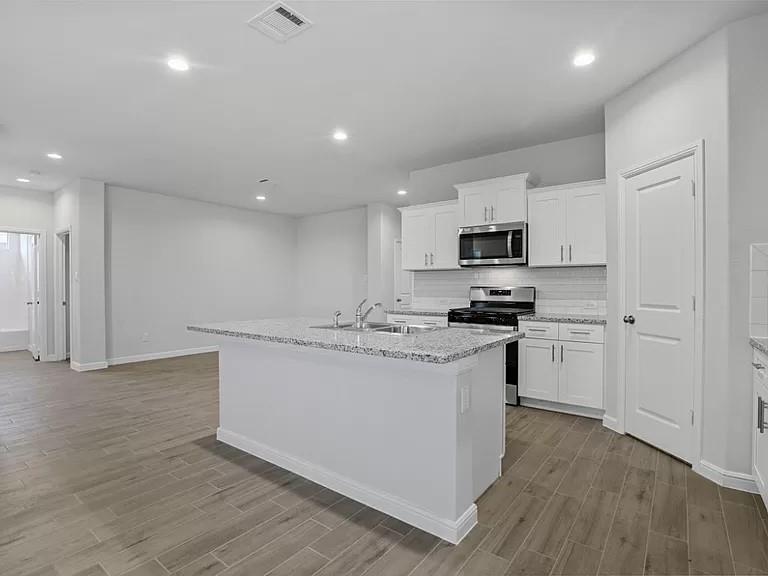 5229 Boulder Vly Drive Fort Worth, TX 76179 - Photo 4 of 39 a kitchen with granite countertop white cabinets and stainless steel appliances