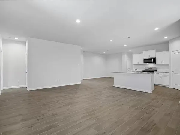 a view of kitchen with granite countertop cabinets and refrigerator