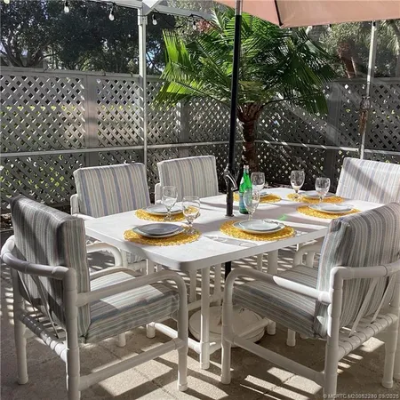 a view of a patio with table and chairs with wooden floor