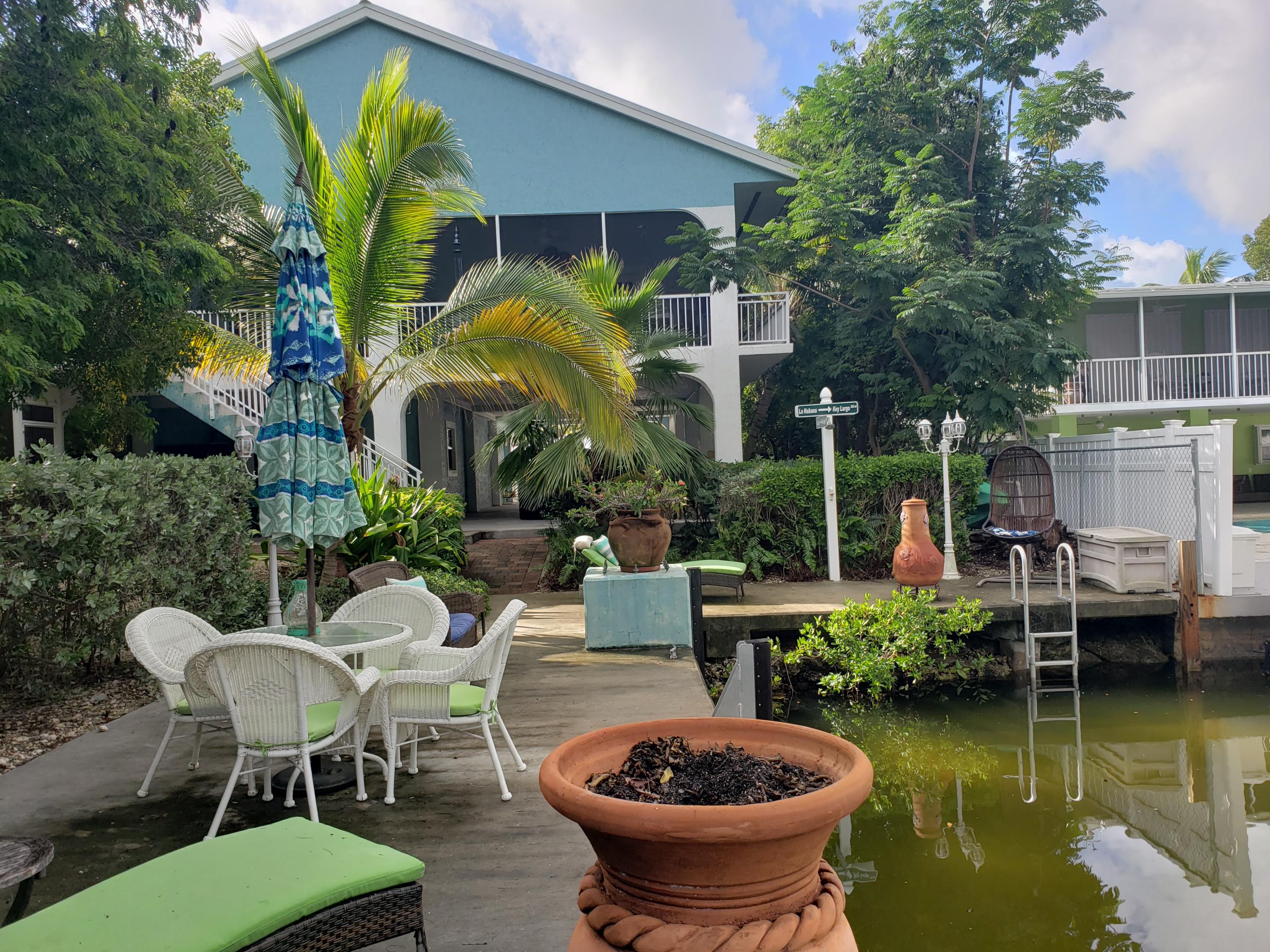 102 Mockingbird Road Tavernier, FL 33070 - Photo 15 of 17 a view of a patio with table and chairs potted plants and a fountain