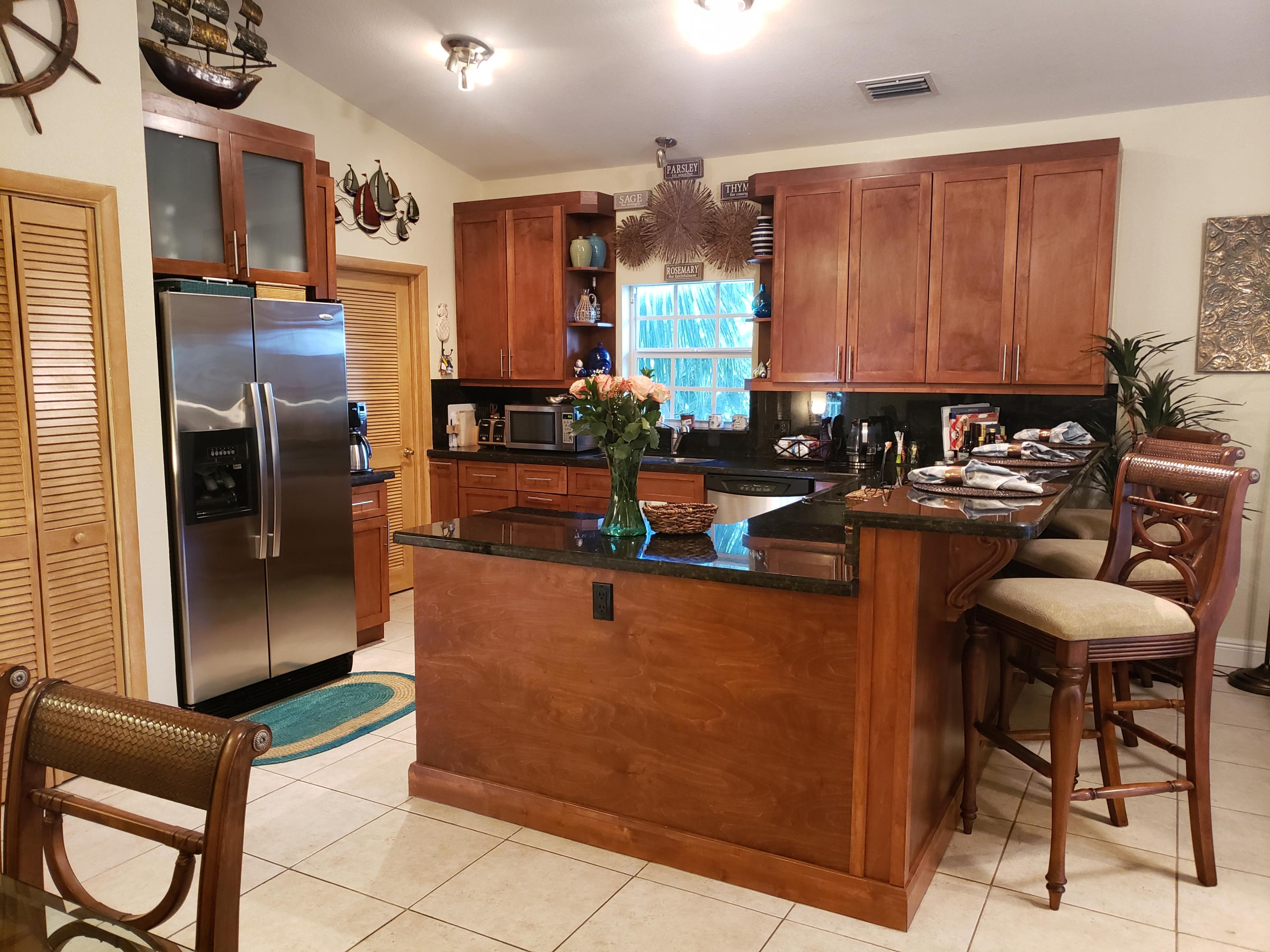 102 Mockingbird Road Tavernier, FL 33070 - Photo 7 of 17 a kitchen with stainless steel appliances granite countertop a refrigerator and a stove