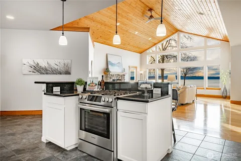 a kitchen with stainless steel appliances granite countertop a stove a sink and a microwave