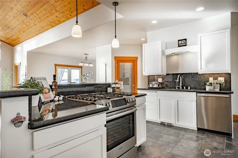 a kitchen with granite countertop a sink stove and cabinets