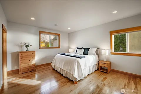 a bedroom with a bed and wooden floor