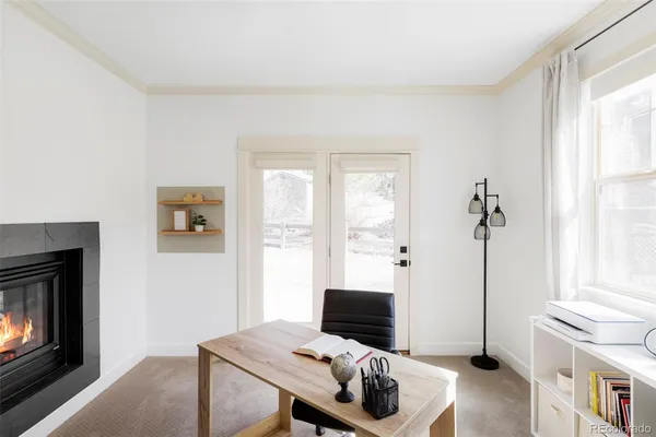 a view of a workspace with furniture and a window