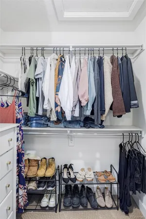 a view of walk in closet with clothes and shoes