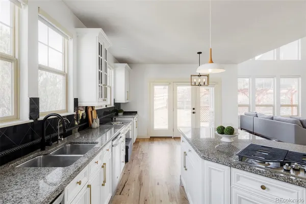a kitchen with stainless steel appliances granite countertop a sink a stove and a granite counter tops with a large window