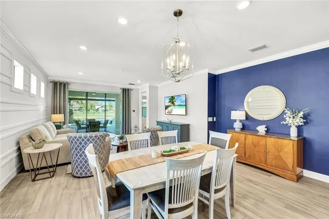 a view of a dining room with furniture a chandelier and wooden floor