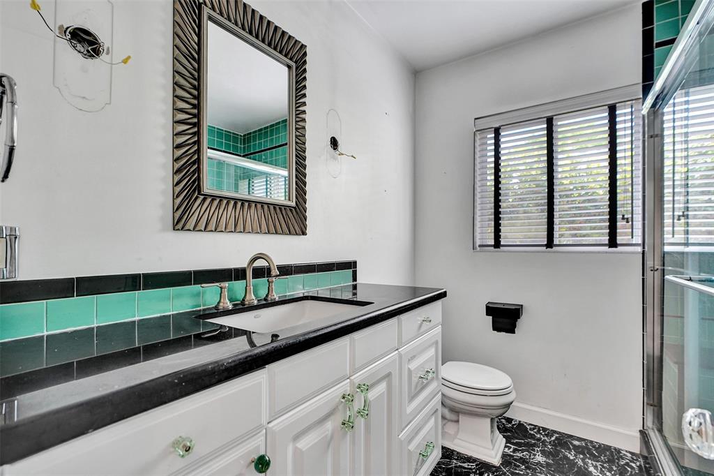 1626 Tyler Street Hollywood, FL 33020 - Photo 12 of 28 a bathroom with a granite countertop sink mirror vanity and toilet