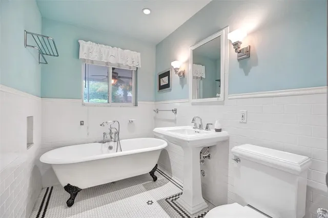 a bathroom with a sink a toilet and mirror