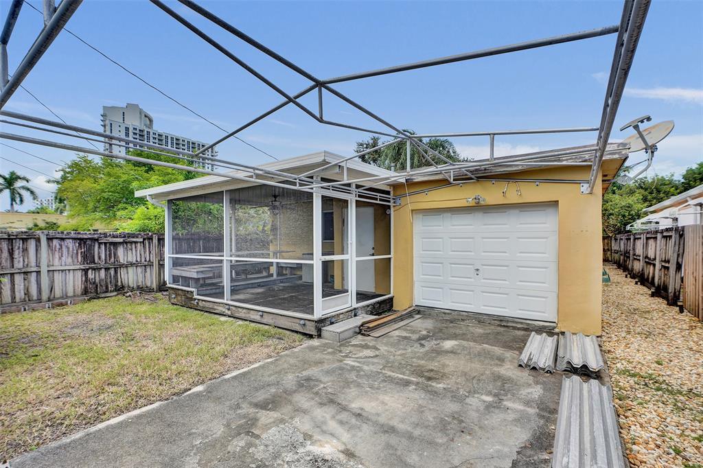 1626 Tyler Street Hollywood, FL 33020 - Photo 23 of 28 a view of a house with a small yard and wooden fence