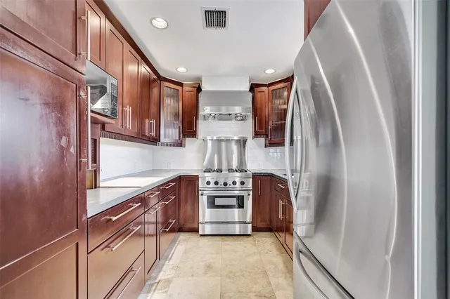 a kitchen with stainless steel appliances granite countertop a refrigerator and a stove