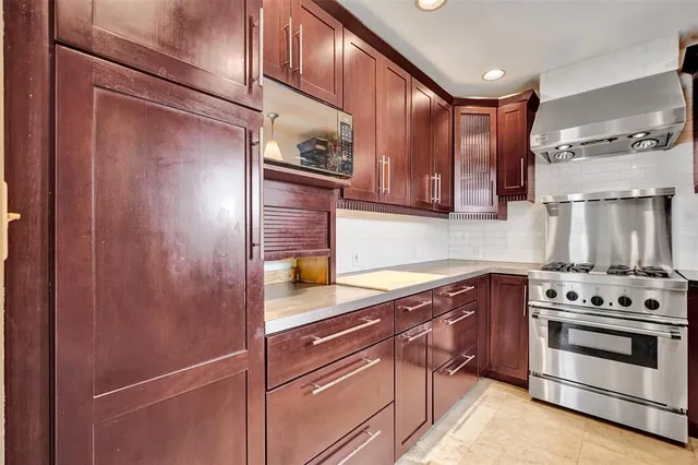 a kitchen with stainless steel appliances granite countertop a refrigerator and a stove