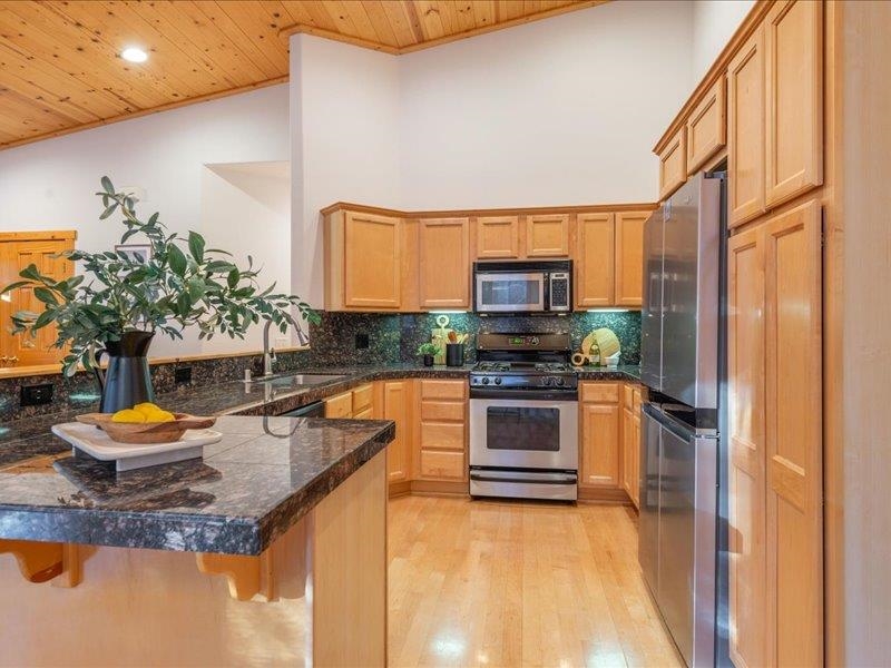 12678 Hidden Circle, Unit 4 Truckee, CA 96161 - Photo 16 of 28 a kitchen with stainless steel appliances granite countertop a sink a stove and a wooden cabinets