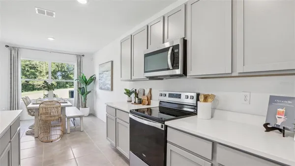 a kitchen with stainless steel appliances a stove a sink a microwave cabinets and a refrigerator