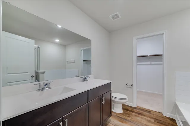 a bathroom with a double vanity sink toilet and mirror