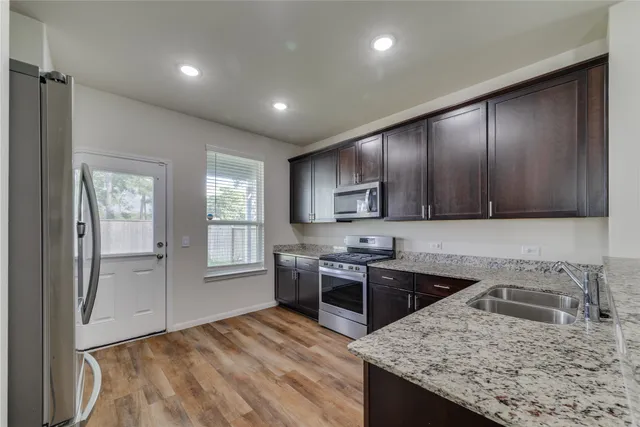 a kitchen with a stove sink and cabinets