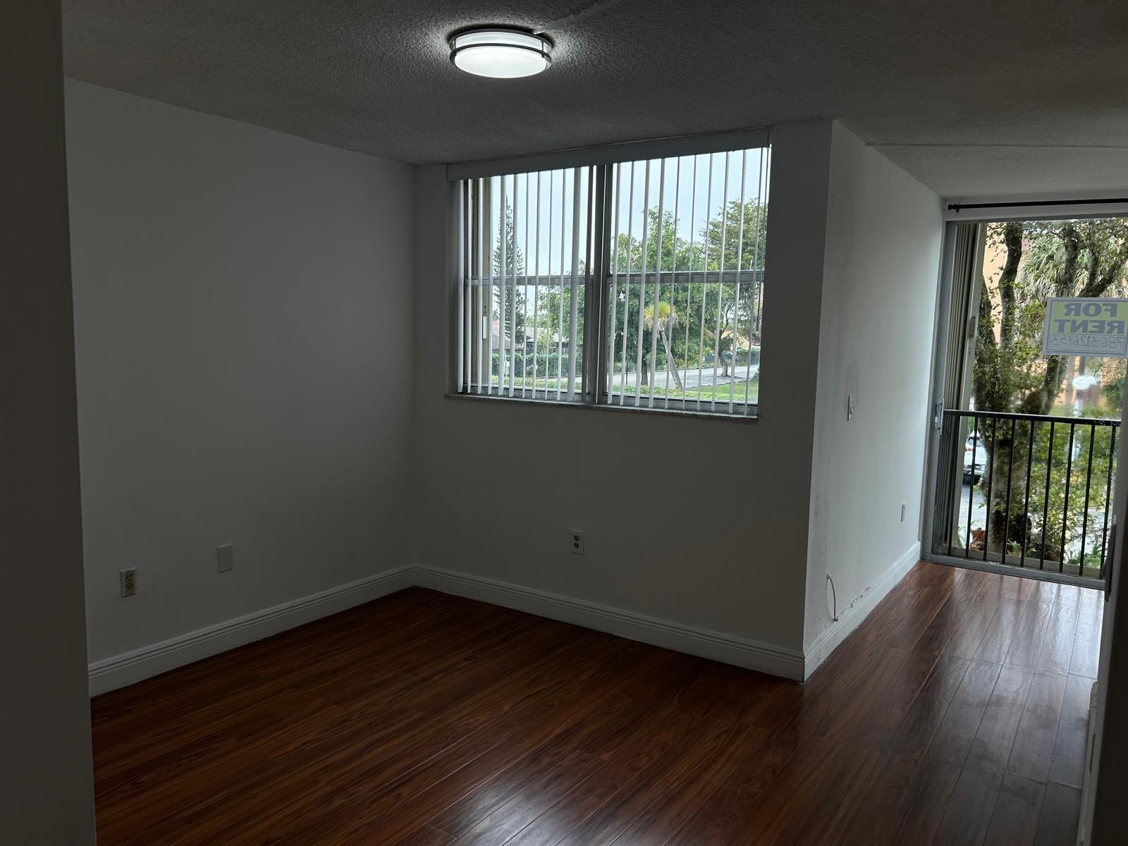 9441 Southwest 4th Street, Unit 202 Miami, FL 33174 - Photo 2 of 21 an empty room with wooden floor and windows