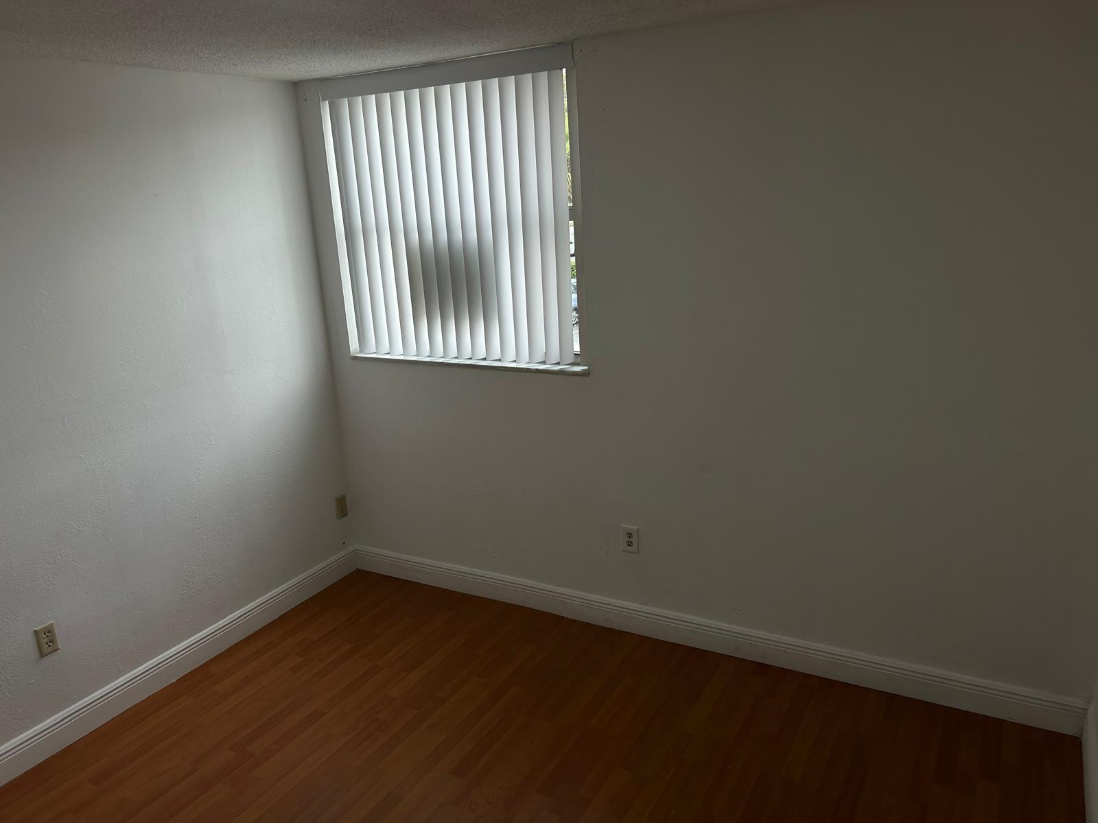 9441 Southwest 4th Street, Unit 202 Miami, FL 33174 - Photo 8 of 21 an empty room with wooden floor and windows