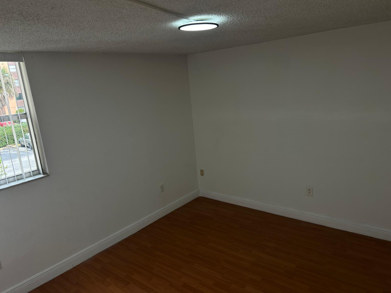 9441 Southwest 4th Street, Unit 202 Miami, FL 33174 - Photo 10 of 21 an empty room with wooden floor and windows