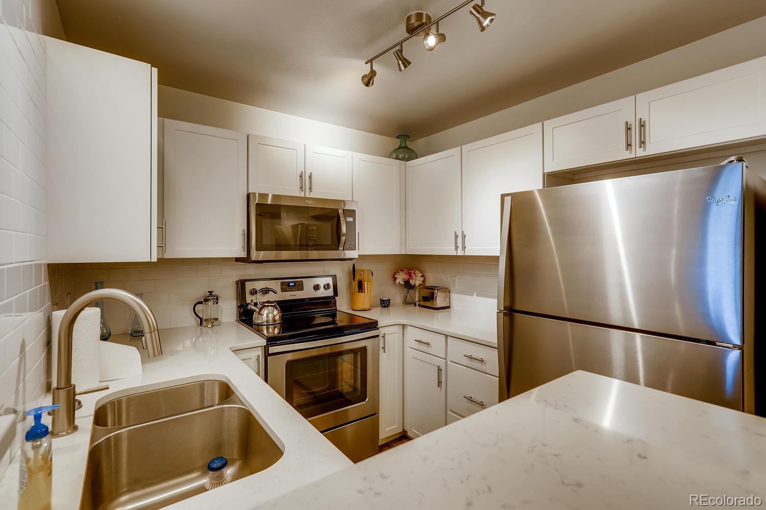 7881 Allison Way, Unit 202 Arvada, CO 80005 - Photo 11 of 26 a kitchen with stainless steel appliances a refrigerator sink and microwave