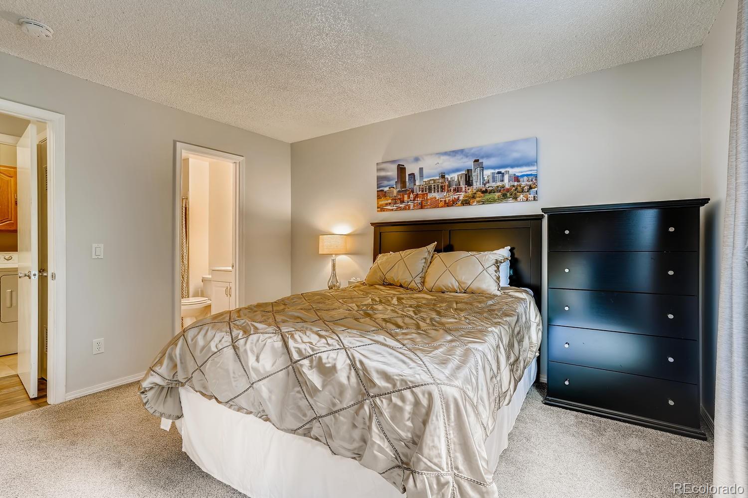 7881 Allison Way, Unit 202 Arvada, CO 80005 - Photo 15 of 26 a bedroom with a bed and a painting on the wall