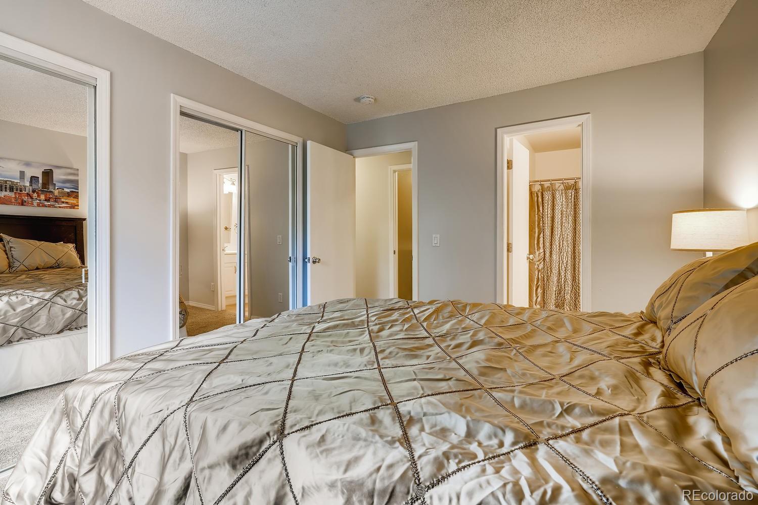 7881 Allison Way, Unit 202 Arvada, CO 80005 - Photo 16 of 26 a bedroom with a bed and a mirror