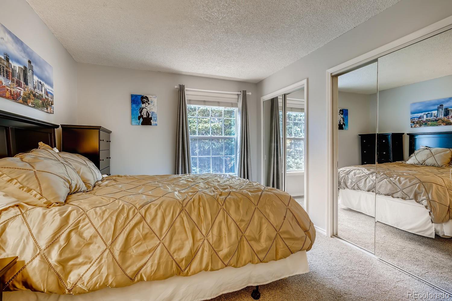 7881 Allison Way, Unit 202 Arvada, CO 80005 - Photo 17 of 26 a bedroom with a bed and glass windows